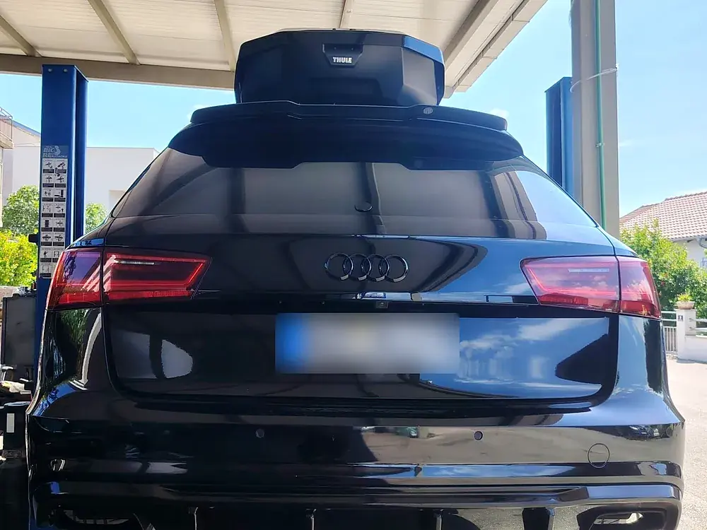 Audi A6 Avant na dizalici pod nadstrešnicom radionice